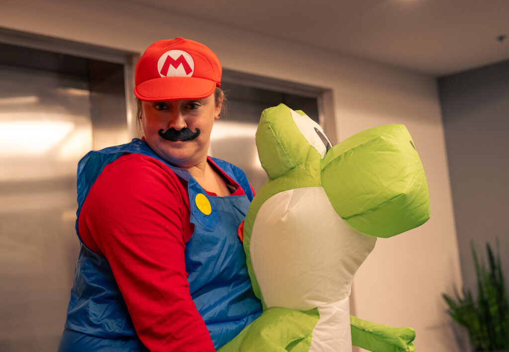 A KCH Transportation employee dressed as Mario riding Yoshi.