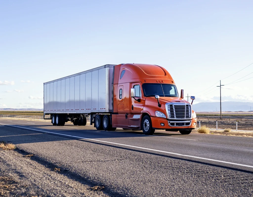 A semi-truck travels down an rural road.
