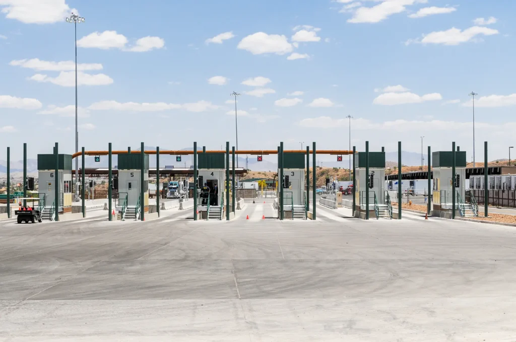 U.S.-Mexico border inspection lanes with automated systems and green-arrow signals at the Nogales-Mariposa Port of Entry customs.